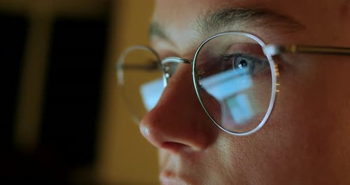 Young Adult Works in Computer Light, Close-Up
