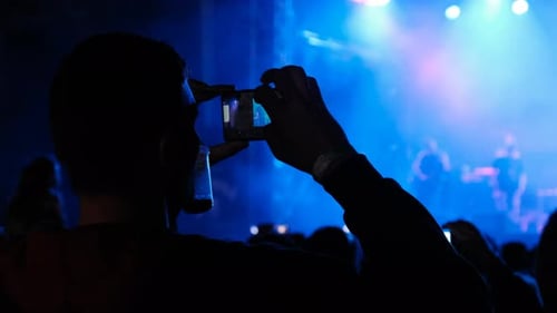 People Filming Rock Concert on Smartphones Silhouettes Crowd of Fans Dancing