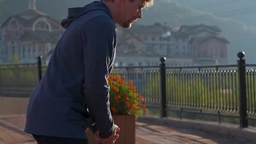 Man Stretching Leg in Urban Setting