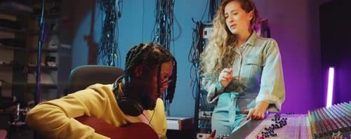 Man and Woman Singing to Guitar in Recording Studio