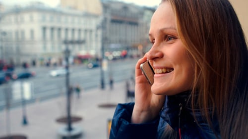 Emotionale Frau telefoniert im Freien