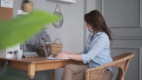 Freelancer Works at Home. Attractive Girl Working at Home on a Laptop