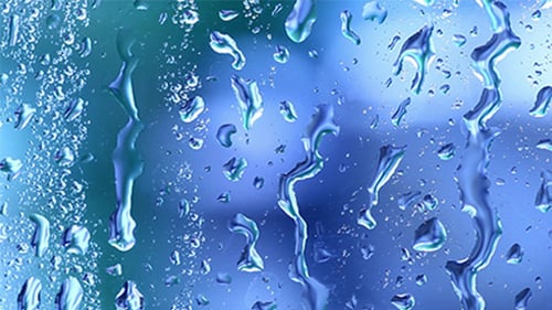 Water Droplets Running Down Blue Glass