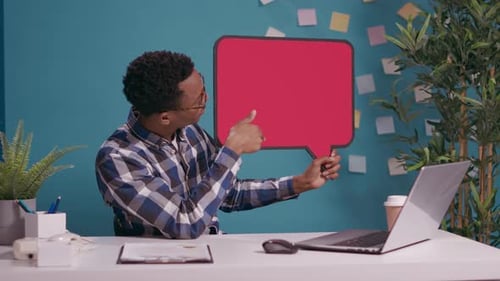 Young Adult Presenting a Speech Bubble in Office