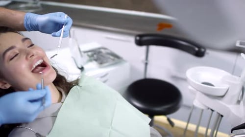 Dentista masculino que examina los dientes de una paciente