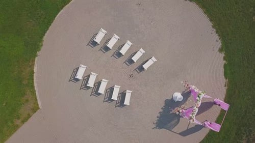 Camera Rises Over Wedding Round Venue in Park on Sunny Day