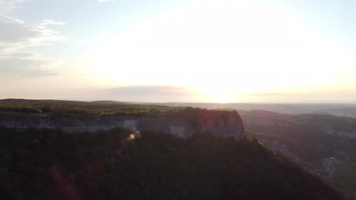 Aerial View of Mountains Next to Cliff Cliff During Sunset