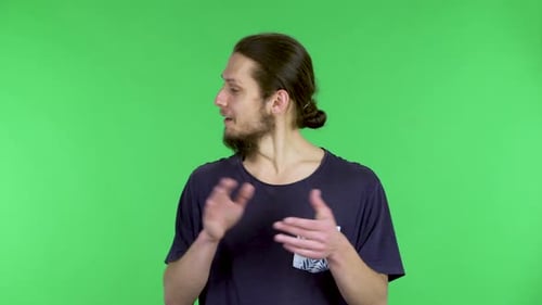 An Impressed Young Bearded Man Applauds on a Green Screen