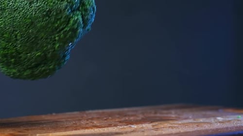 Professional cook puts lush green broccoli on board macro