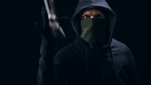 Räuber in Maske Rollende Pistole am Finger