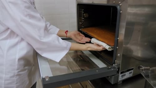 Baker Removing Cake from a Commercial Oven