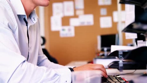 Young Adult Typing on Computer at Bright Office