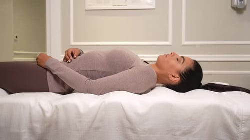 Woman Lies Relaxed on Medical Examination Bed