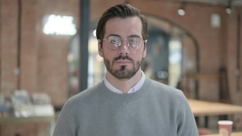 Man with Beard and Glasses Stares into Camera