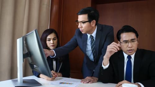 Geschäftsleute arbeiten zusammen am Schreibtisch und überprüfen einen Finanzbericht.