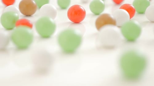 Lot of various color bonbons on the white shiny and reflective background 4K 3840X2160 UHD video - M