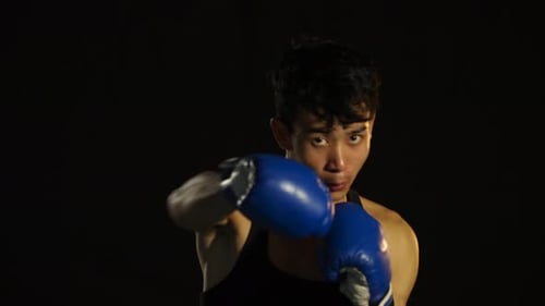 Young Boxer Punching with Blue Boxing Gloves