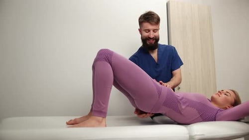 Physical Therapist Massaging Female Patient in Clinic