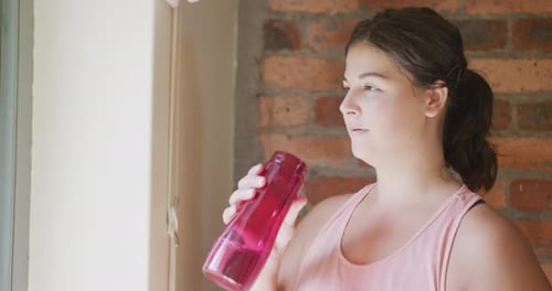 Caucasian vlogger woman drinking water at home