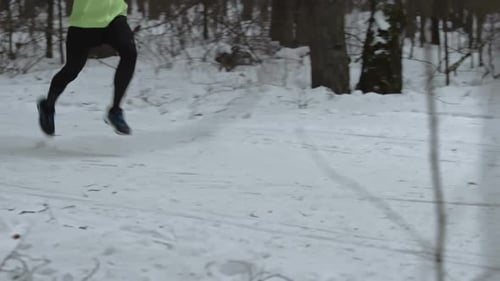 Athlete Running Through Snowy Winter Woods