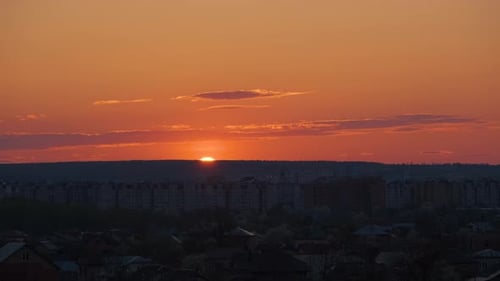 Evening Landscape with Bright Setting Sun Over Distant City High Rise Buildings at Sunset
