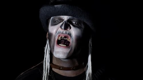 Frightening Man in Skeleton Halloween Costume Appearing From Darkness When Light Falls on Him