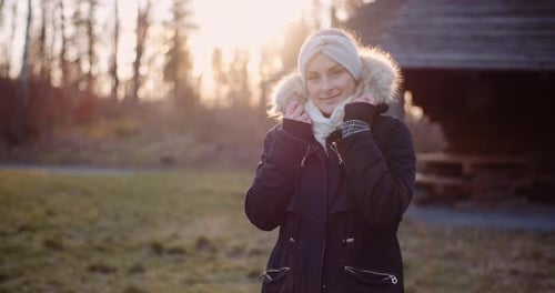 Smiling Woman in Winter Coat at Sunset