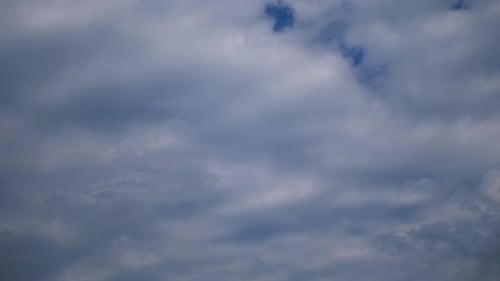 Fluffy Clouds Moving Across Light Blue Sky