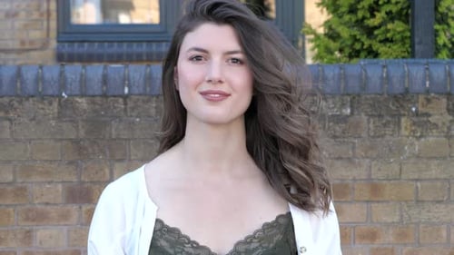 Woman Smiling at Camera in Urban Setting