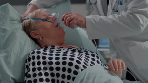 Doctors Applying Oxygen Mask to Patient in Hospital