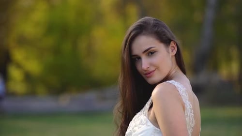 Portrait of Beautiful Brunette Woman with Long Hair Is Posing in Sunny Rays at Autumn Park