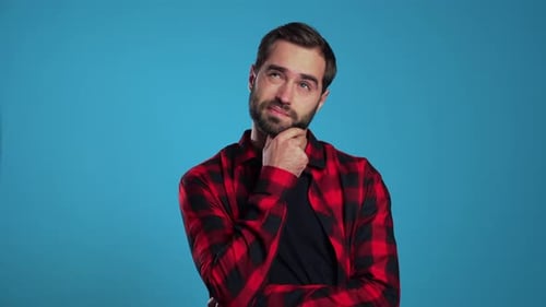 Thoughtful Man Posing on a Blue Background
