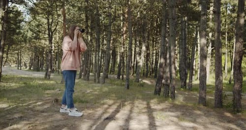 Young Woman Photographer Takes Pictures of the Forest Using Digital Camera