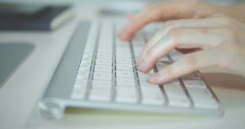 Fingers Typing on White Computer Keyboard