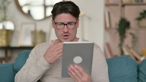 Man Using Tablet for Video Call at Home