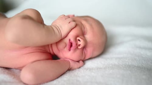 Sleeping Newborn Baby on White Blanket Close-Up