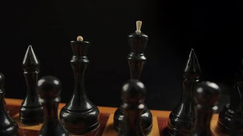 Classic Black Chess Pieces on Wooden Board