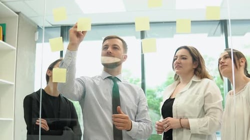 Young Corporation Employees are Discussing a Business Plan with Stickers in the Office