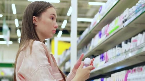 Female Buyer is Choosing Rollon Deodorant in Cosmetic Shop