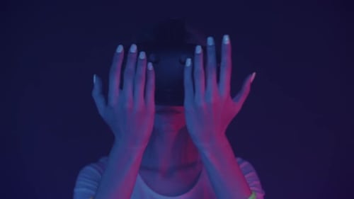 Close Up of Young Girl in Virtual Reality Glasses Puts Hands in Front of Her Face Looks at Them