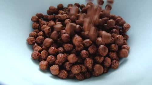 Chocolate Cereal Pours Into Bowl in Bright Daylight