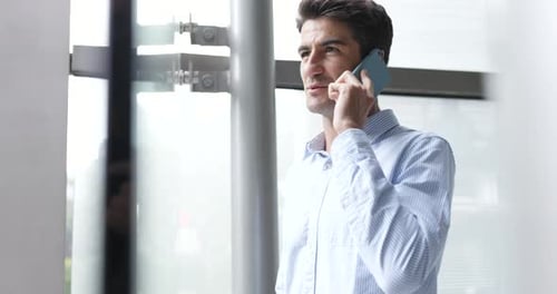Young Adult Man Talking on Phone in Office
