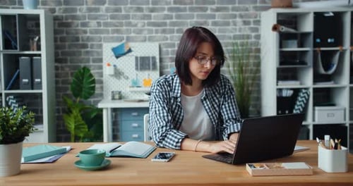 Woman Working At Desk, Smiling At Camera