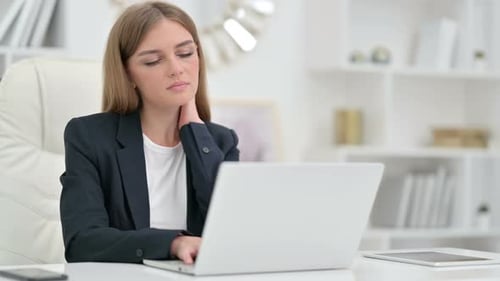 Tired Businesswoman Having Neck Pain in Office