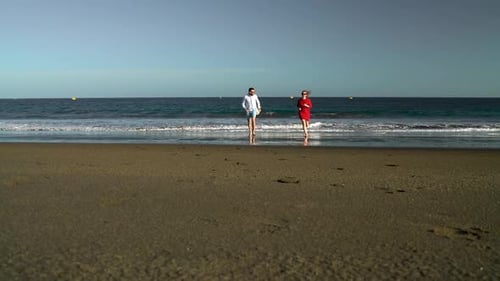 Couple in Love Carefree Running From the Water on the Beach