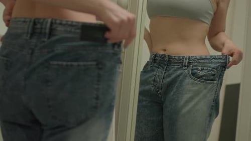Woman Wearing Oversized Jeans in Mirror