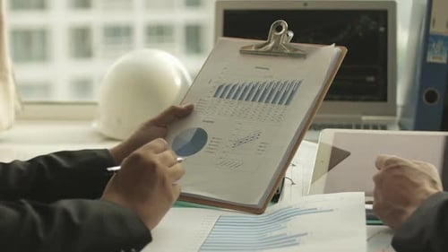 Business People Review Charts and Graphs in Office