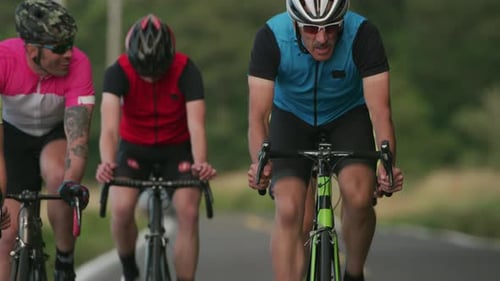 Tracking-Aufnahme einer Gruppe von Radfahrern auf einer Landstraße. Vollständig für den kommerziell Gebrauch freigegeben.
