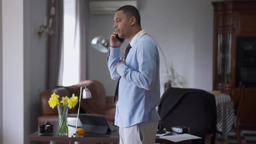 Side View of Professional African American Businessman Talking on the Phone Having Sudden Severe