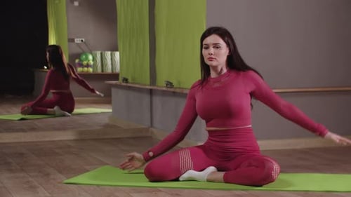 Woman Performing Stretches in Indoor Gym